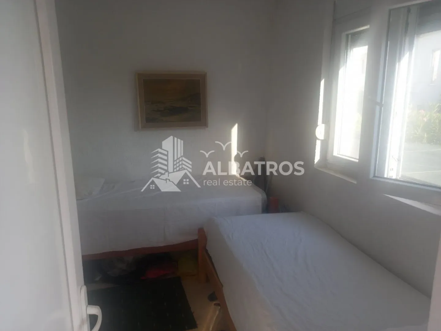 Smaller bedroom with two single beds and a window.