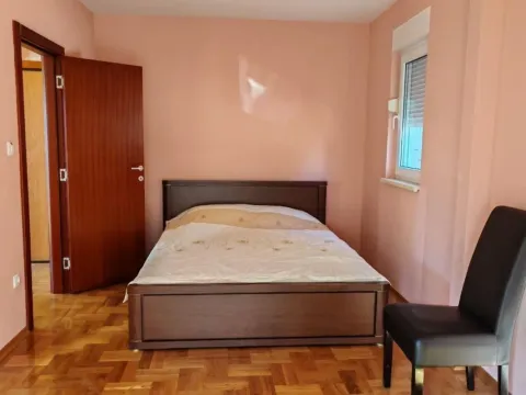 Spavaća soba sa bračnim krevetom, drvenim parketom i vratima koja vode u hodnik. - image 6