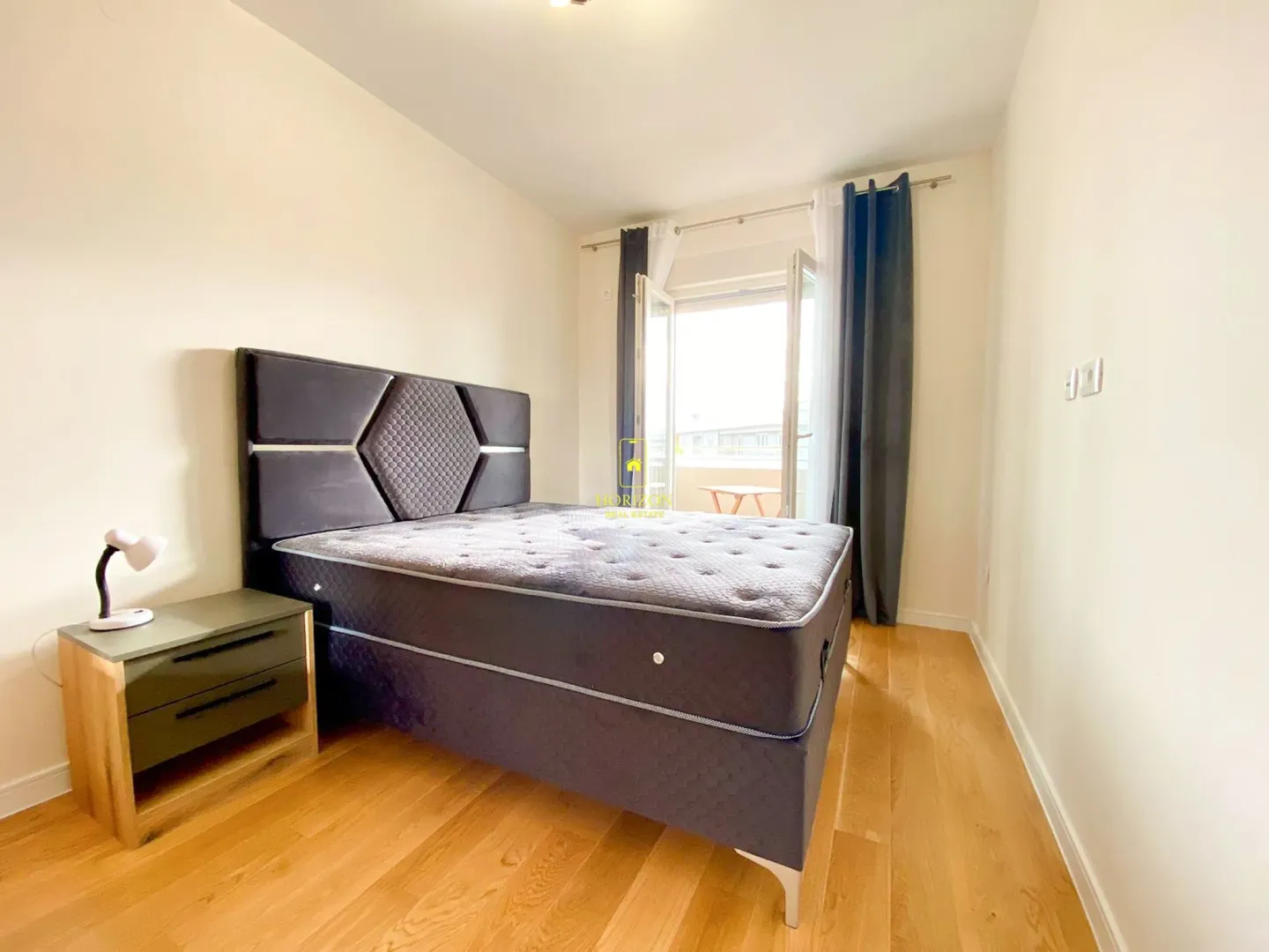 Bedroom with a double bed, bedside table, and access to the terrace.