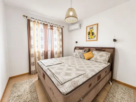 Namještena spavaća soba sa bračnim krevetom, klima uređajem i prozorom sa zavjesama. - image 9