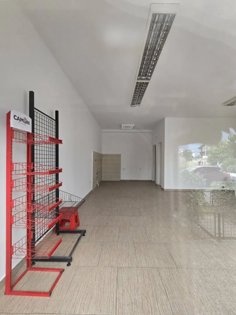 Empty commercial space with tiled floors and a large window.