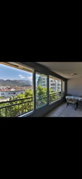 Enclosed balcony with a view of the city and mountains. - image 8