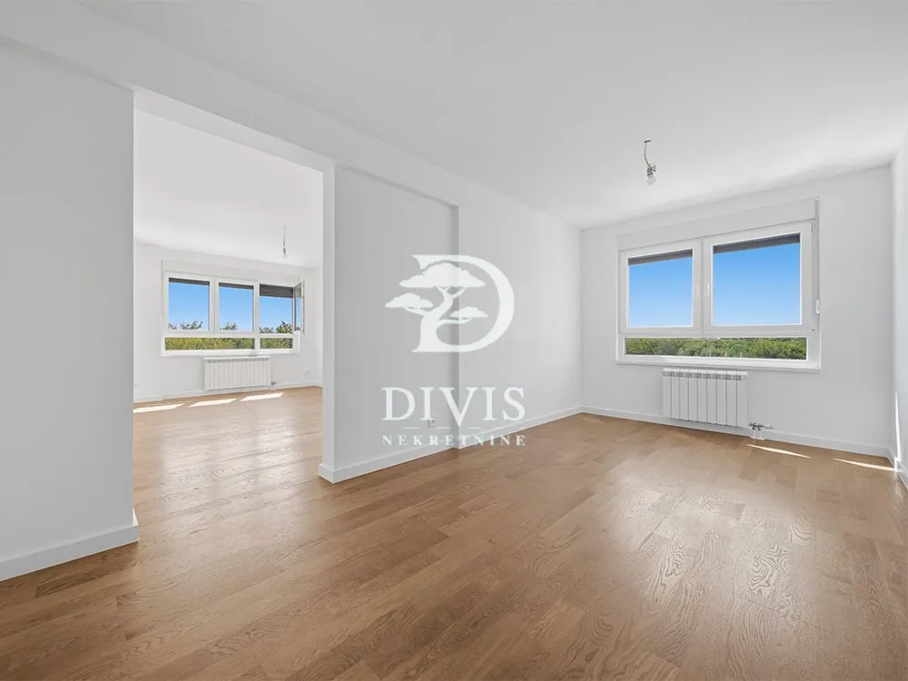 Empty bright room with hardwood floors and white walls.