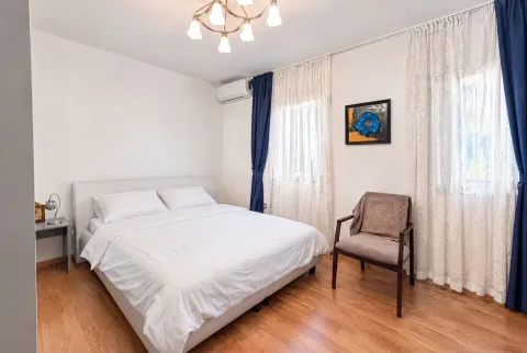 Furnished bedroom with a double bed, an armchair, and wooden flooring. - image 15