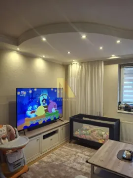 Dnevna soba sa televizorom i dečijim krevetcem. - image 2