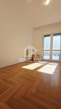 Empty room with hardwood parquet flooring and balcony doors. - image 4