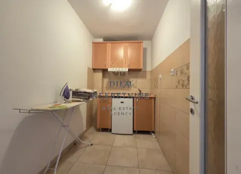Small kitchen with wooden units and an ironing board. - image 3