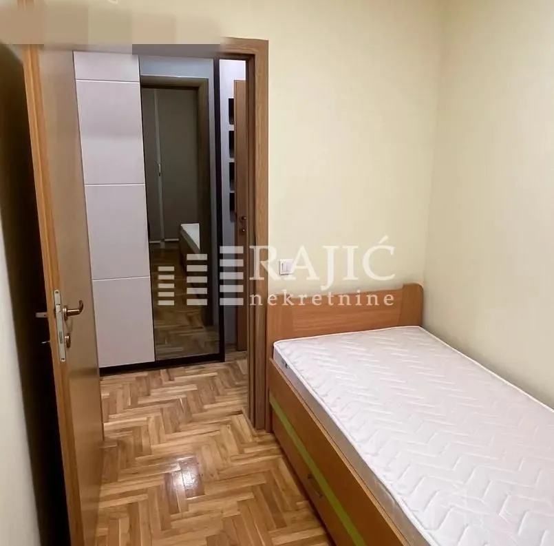 Smaller bedroom with a bed and wardrobe in an apartment.