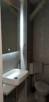 Small bathroom with a washbasin, illuminated mirror, and toilet. - image 3