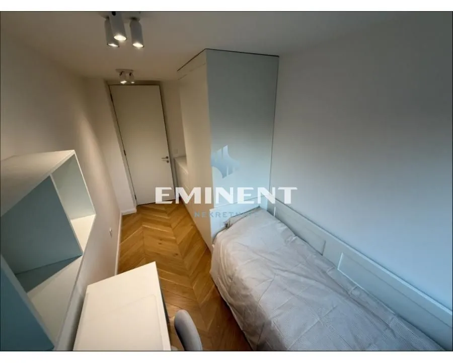 Smaller bedroom with a bed and a desk.