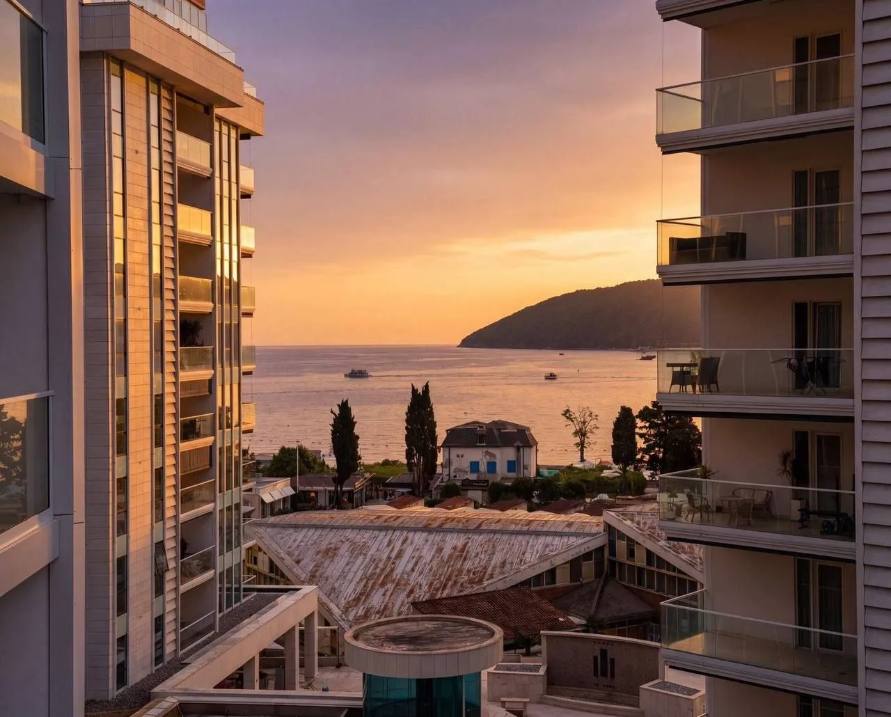 View from the terrace of the sea and sunset between buildings.