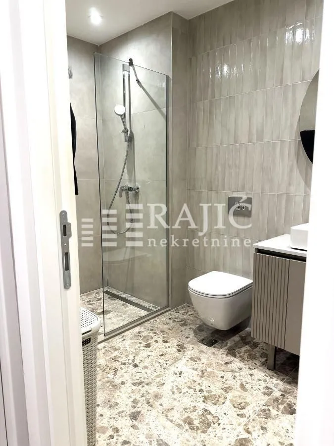 Modern bathroom with a walk-in shower and sanitary fixtures.