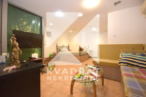 Living room with a bed and a television. - image 5