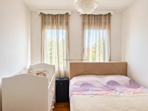 Spavaća soba sa bračnim krevetom i dječijim krevetcem pored prozora. - image 5