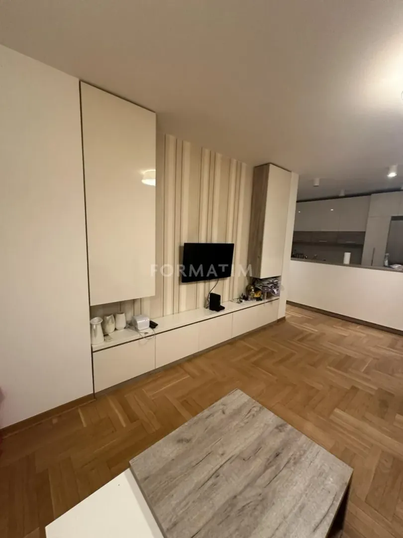 Living room with a TV and parquet flooring.