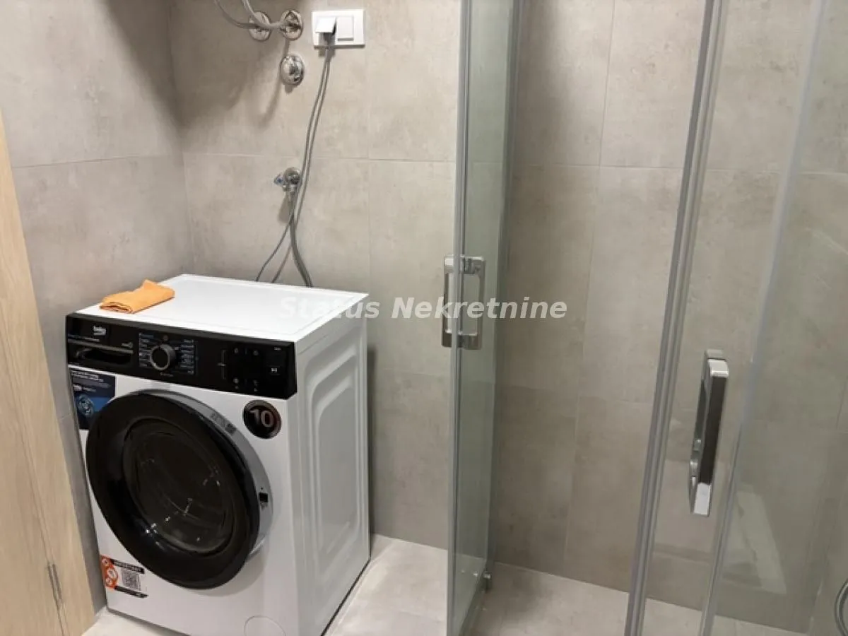Kupatilo sa tuš kabinom i veš mašinom.