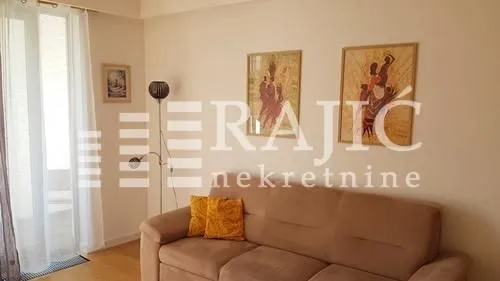 Living room with a sofa and paintings on the wall.