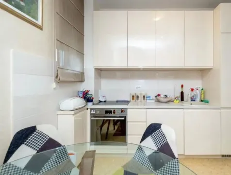 Small bright kitchen with white cabinets and a built-in oven. - image 3