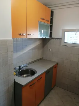 Small kitchen with orange cabinets and a sink. - image 8
