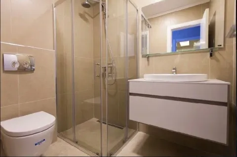 Modernly equipped bathroom with a shower cabin, washbasin, and toilet. - image 13