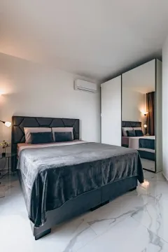 Modern bedroom with a double bed and a large mirrored wardrobe. - image 5