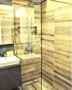 Modern bathroom with a walk-in shower and wood-effect tiles. - image 15