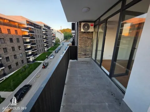 Dugačak popločani balkon sa pogledom na ulicu i okolne zgrade. - image 16