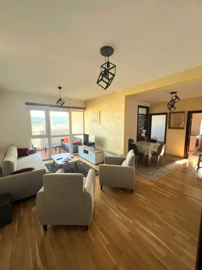Spacious living room with seating area and a dining space in the background.