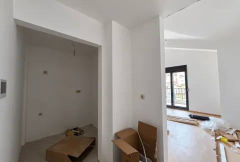 Prazna prostorija u izgradnji sa bijelim zidovima i građevinskim materijalom na podu. - image 13
