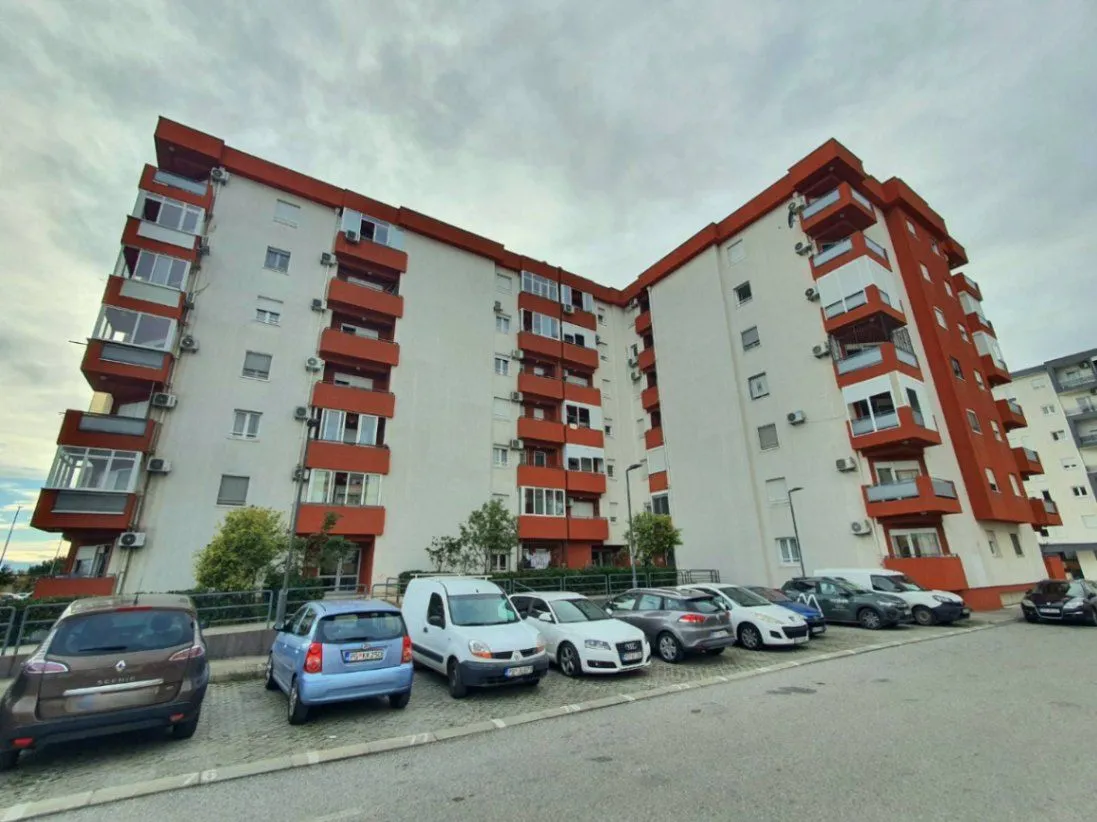 Exterior view of an apartment building with parking in front.