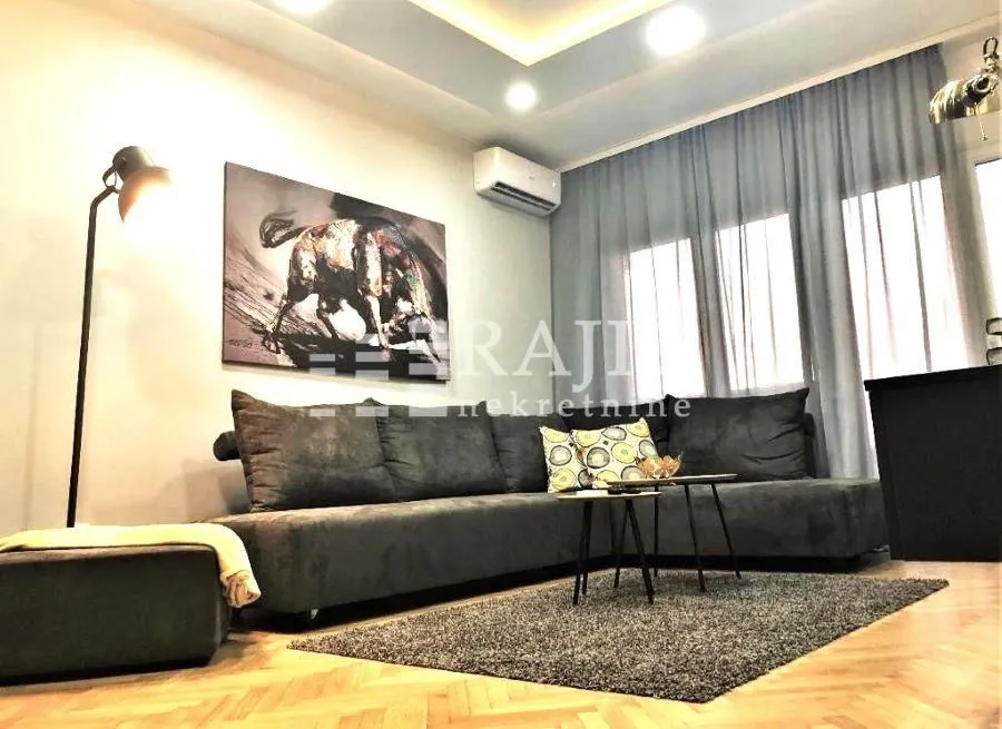 Living room with a sofa and parquet flooring.