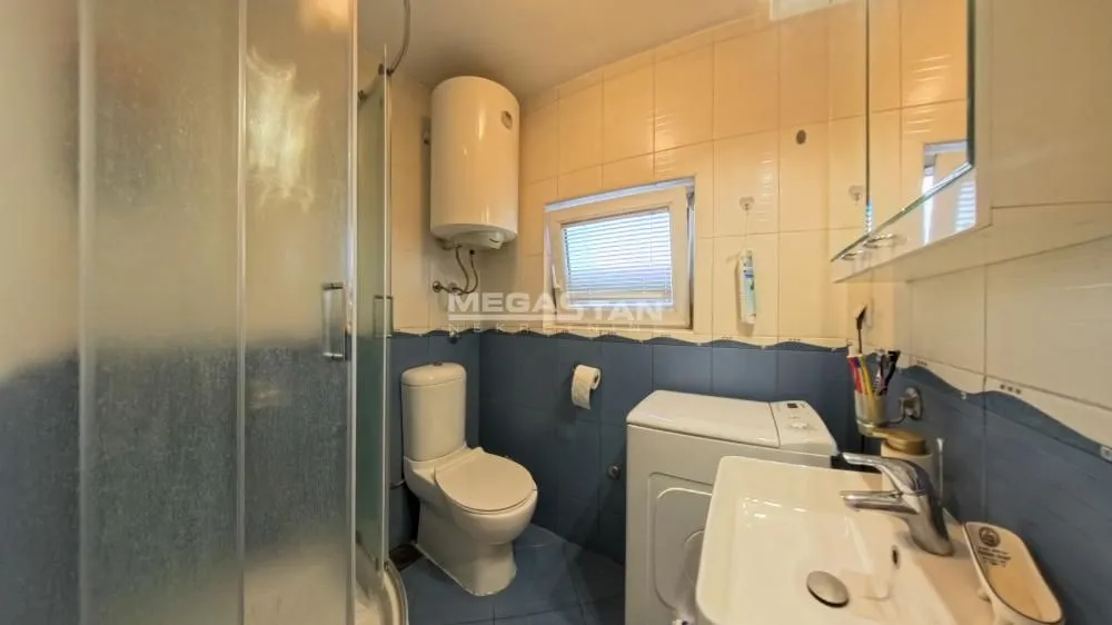 Kupatilo opremljeno tuš kabinom, WC šoljom, umivaonikom i veš mašinom.