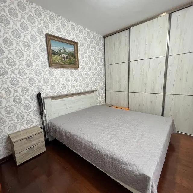 Bedroom with a double bed, bedside table, and a large built-in wardrobe.