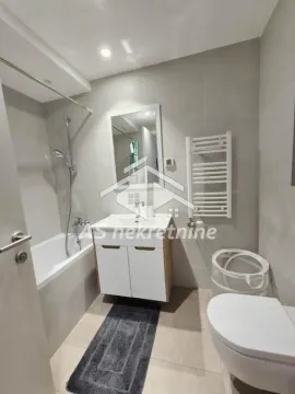 Modern bathroom equipped with a bathtub, vanity unit with washbasin, and toilet. - image 13