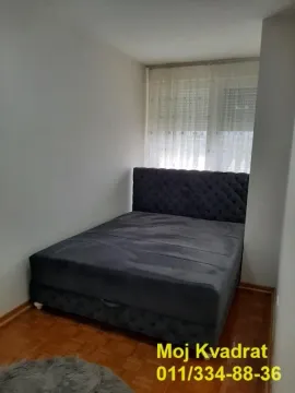 Smaller bedroom with a double bed and parquet flooring. - image 6