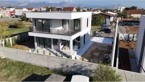 Pogled iz vazduha na modernu dvospratnu kuću sa dvorištem i ogradom. - image 9