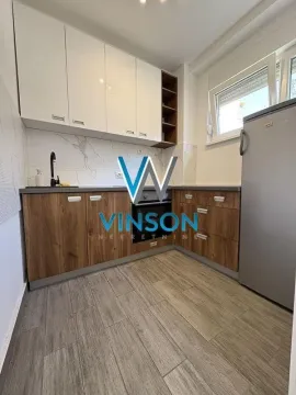 Small kitchen with white and wooden cabinets and a refrigerator. - image 7