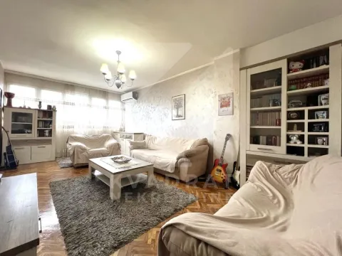 Living room with a sofa set, coffee table, and built-in bookcase. - image 2