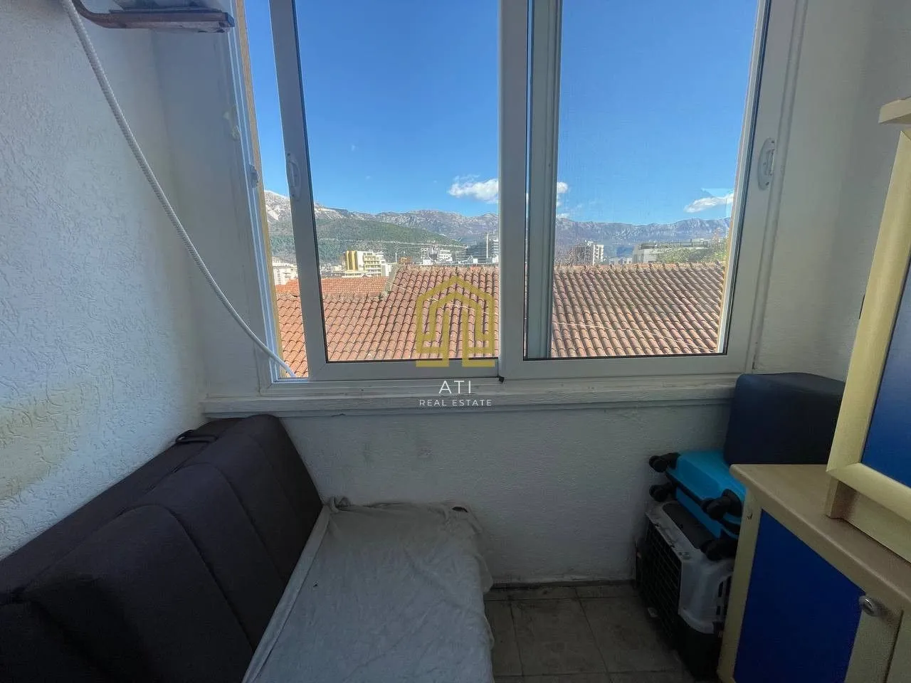 Smaller bedroom with a bed and a view of the mountains through the window.