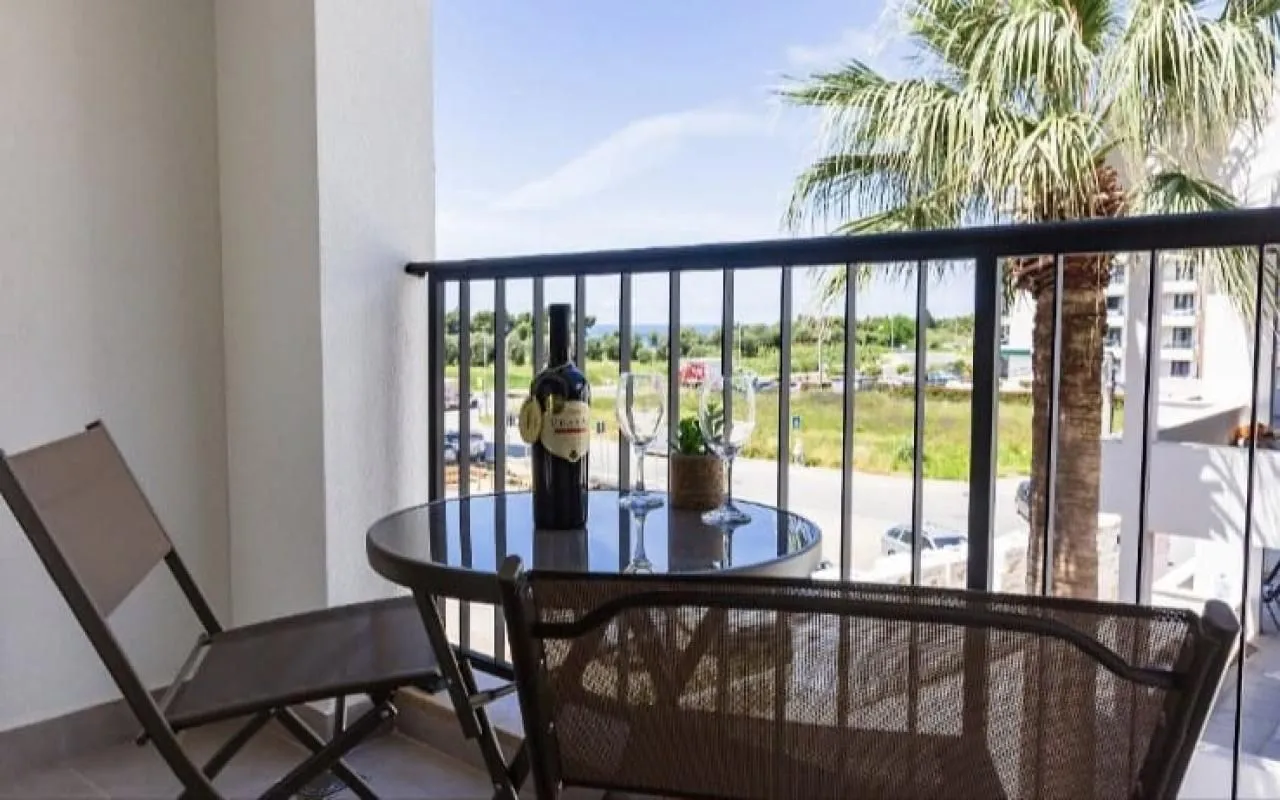 Furnished balcony with a table, chairs, and a view of the surroundings.