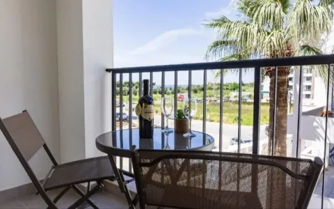 Furnished balcony with a table, chairs, and a view of the surroundings. - image 6