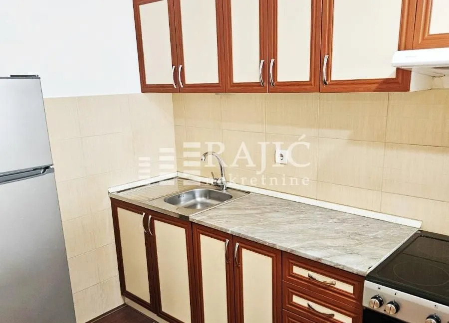 Small kitchen with wooden cabinets and a sink.