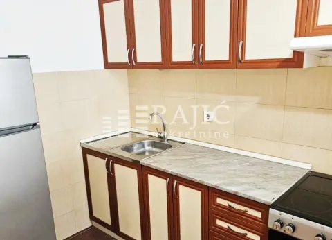 Small kitchen with wooden cabinets and a sink. - image 9