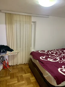 A bedroom featuring a double bed and a window with curtains. - image 12