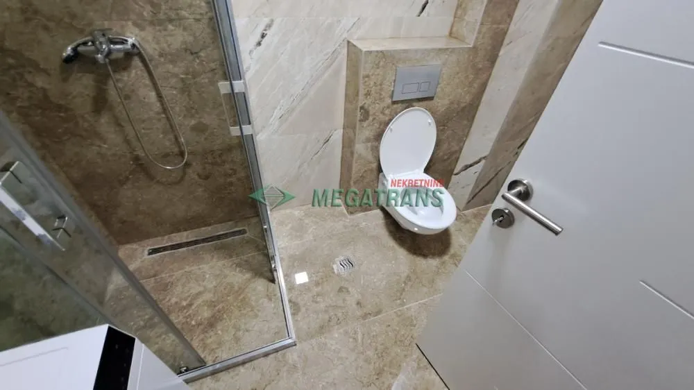 Moderno opremljeno kupatilo sa tuš kabinom i wc šoljom.