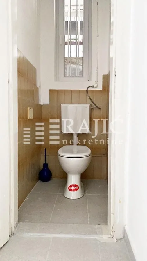 Small bathroom with a toilet and ceramic tiles.
