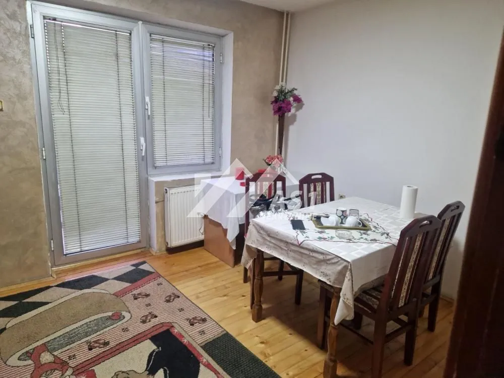 Trpezarijski sto sa stolicama u dnevnoj sobi sa izlazom na terasu.