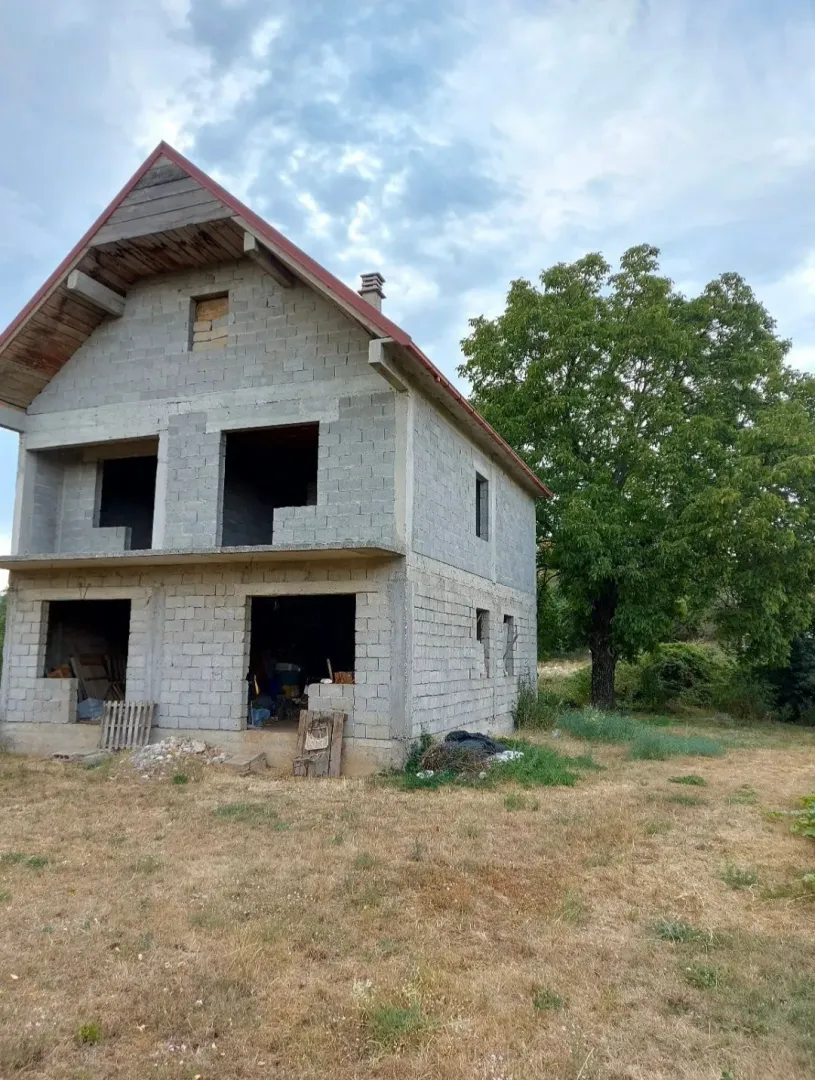 Nedovršena dvospratna kuća u izgradnji sa dvorištem.
