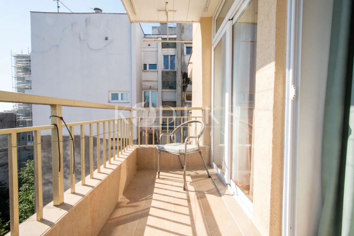 Manji namješteni balkon sa metalnom ogradom i stolicom.