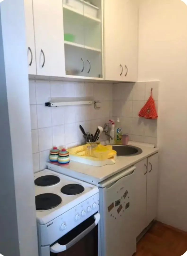 Small white kitchen with a stove and a sink.